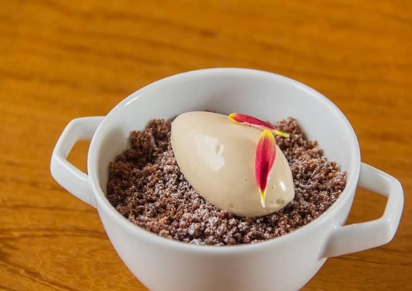 Creme morno de chocolate belga, servido com sorvete de doce de leite e crumble de amêndoas com cacau