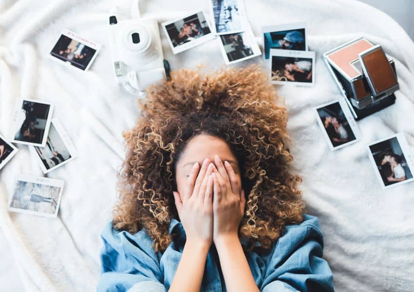 Mulher deitada com muitas fotos