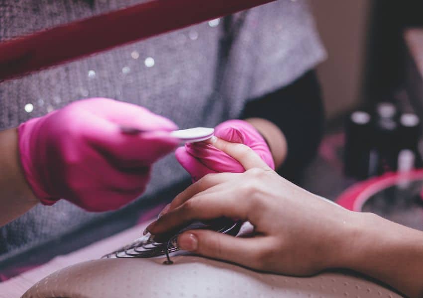 Mulher cuidando das unhas na manicure