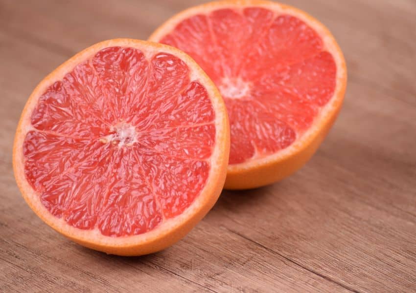 duas metades de toranja em uma superfície de madeira.