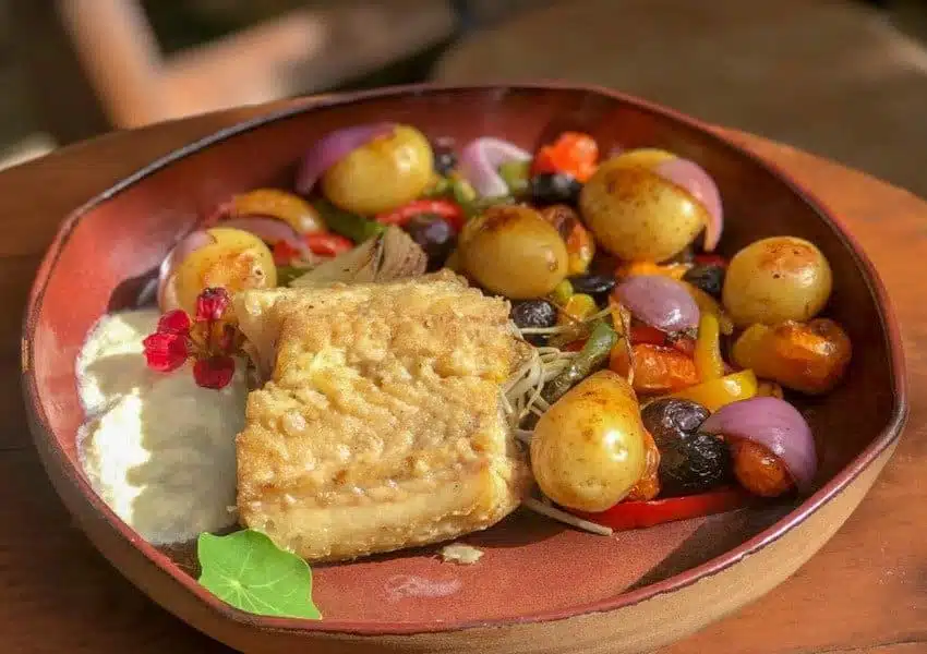 Kit de almoço de Páscoa do Carrefour com bacalhau gratinado, arroz e bolo de Páscoa sobre mesa decorada