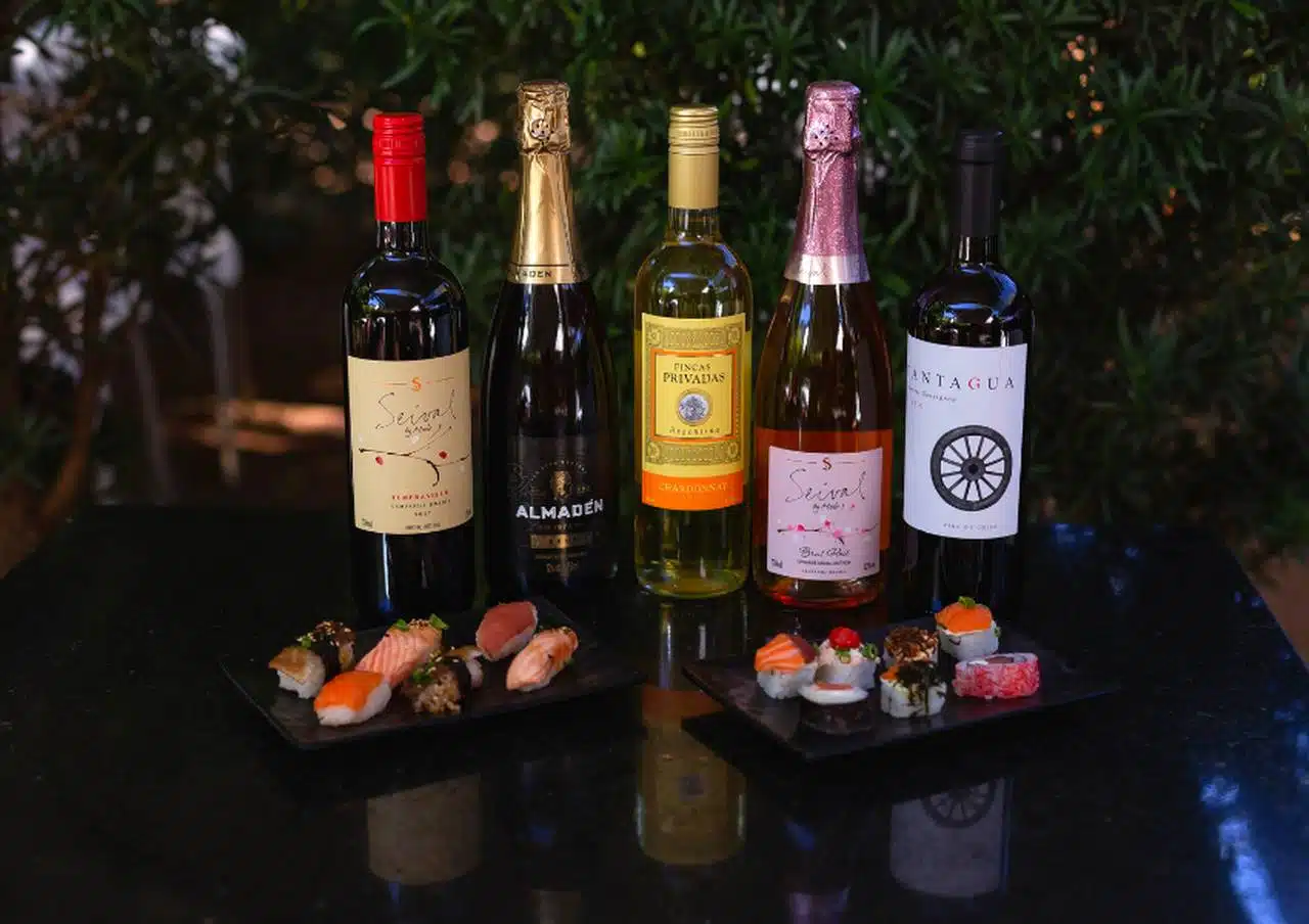 Carta de vinhos do restaurante Haná com rótulos nacionais e internacionais dispostos sobre mesa de madeira