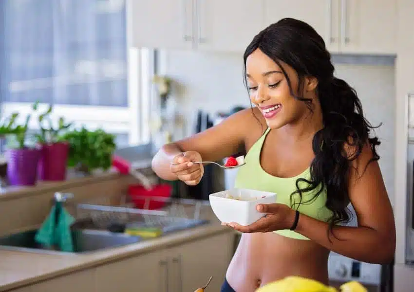 Copo de suco verde sobre mesa com frutas e vegetais frescos, representando a dieta detox