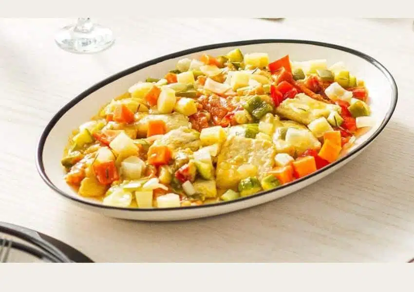 Peixe assado no forno com legumes coloridos em travessa, pronto para servir
