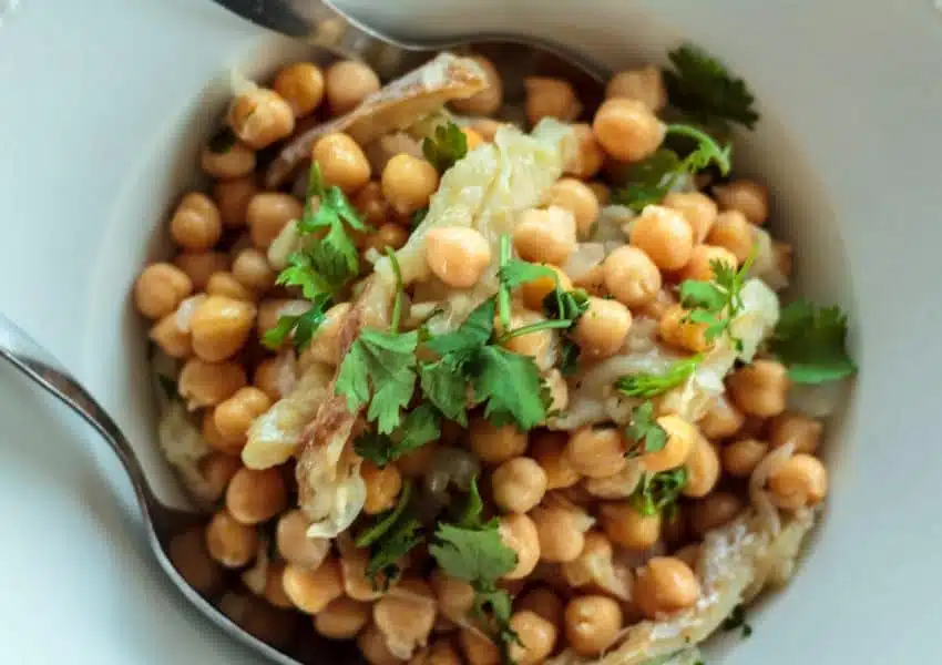 uma tigela branca cheia de feijão e verduras.